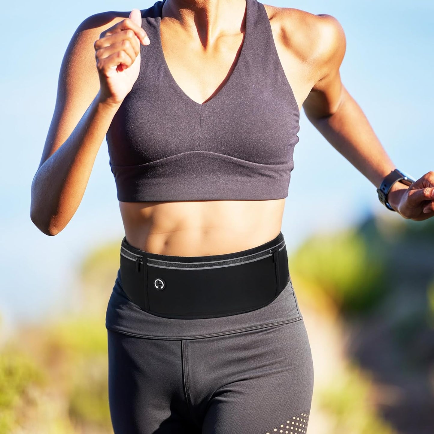 Woman demonstrating phone holder pocket on waterproof workout fanny pack