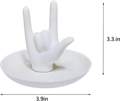 White ceramic hand jewelry tray holding engagement and wedding rings