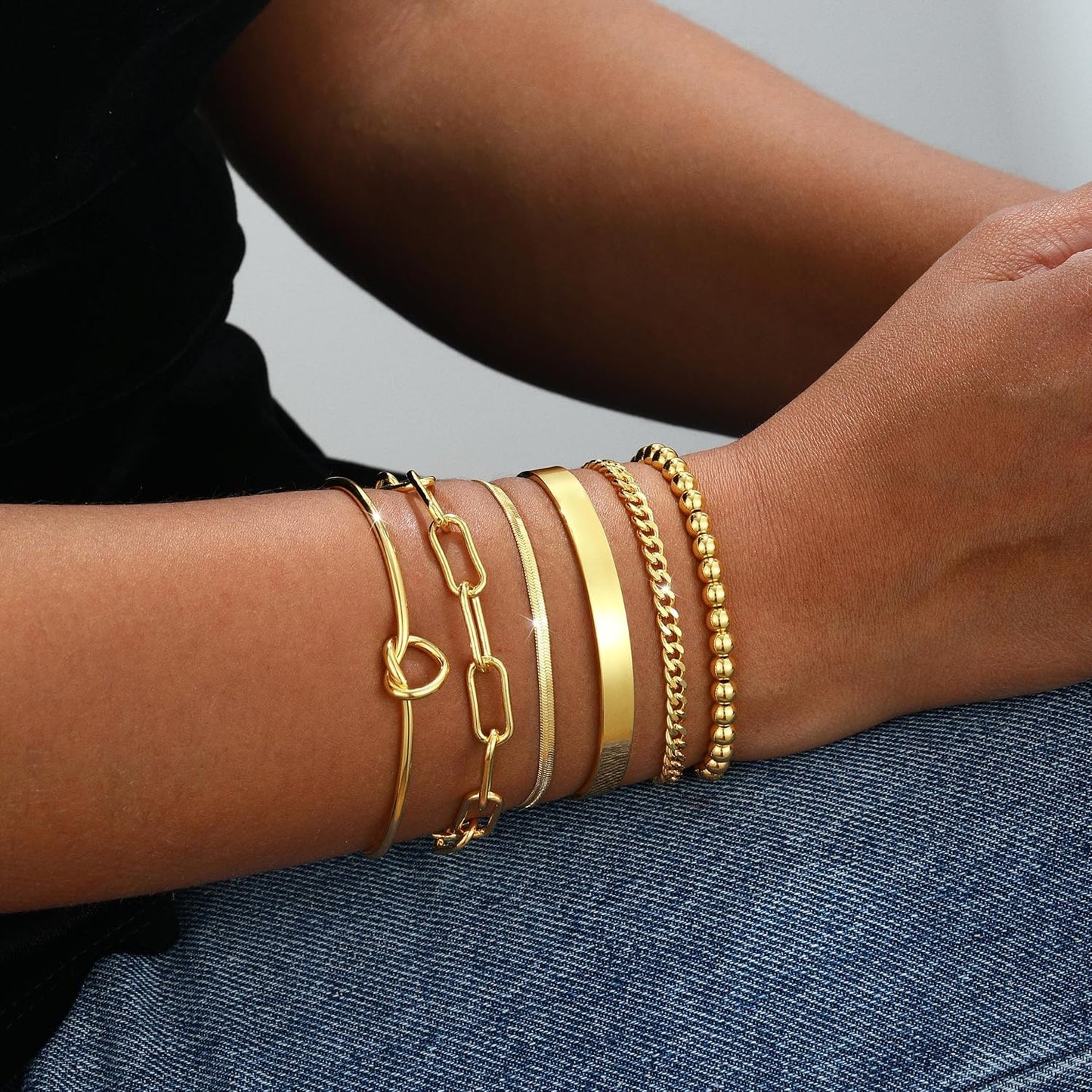 Adjustable gold bangle bracelets worn on woman's wrist