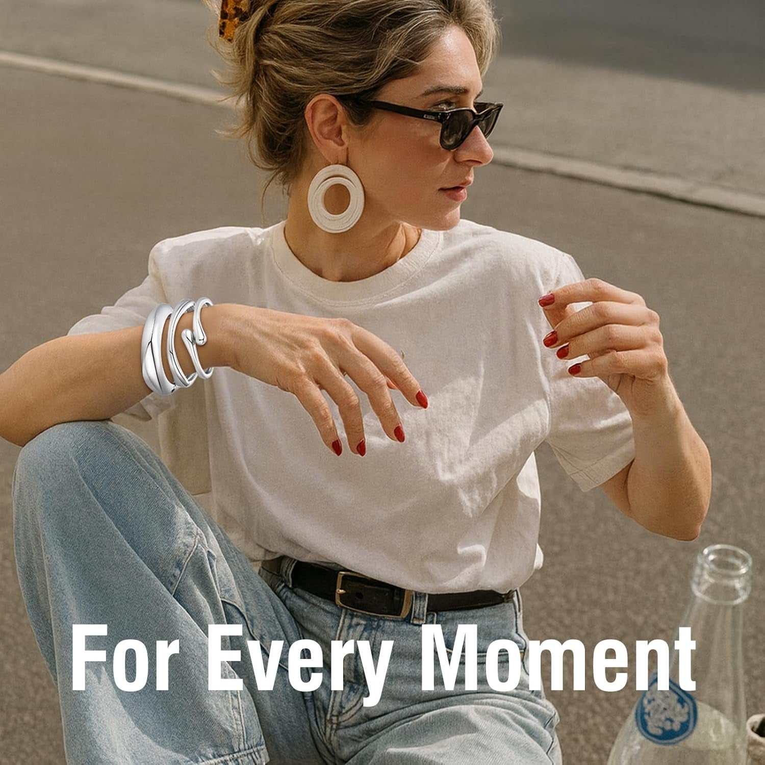 Woman wearing multiple chunky gold plated cuff bracelets stacked together