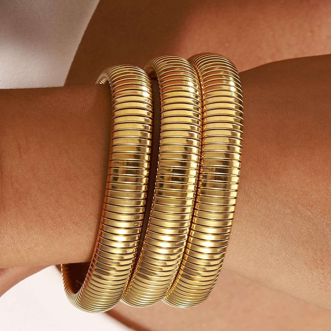 Set of 3 wide gold plated bangle bracelets in stackable arrangement