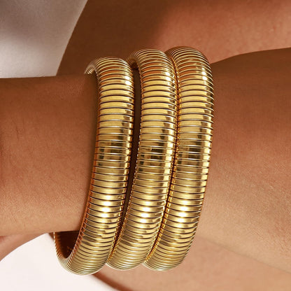 Set of 3 wide gold plated bangle bracelets in stackable arrangement