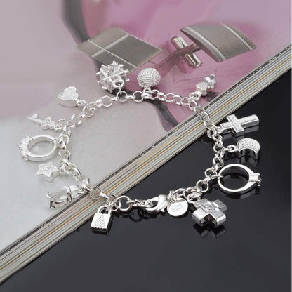 Close-up of sterling silver charm details including heart, star, and cross symbols