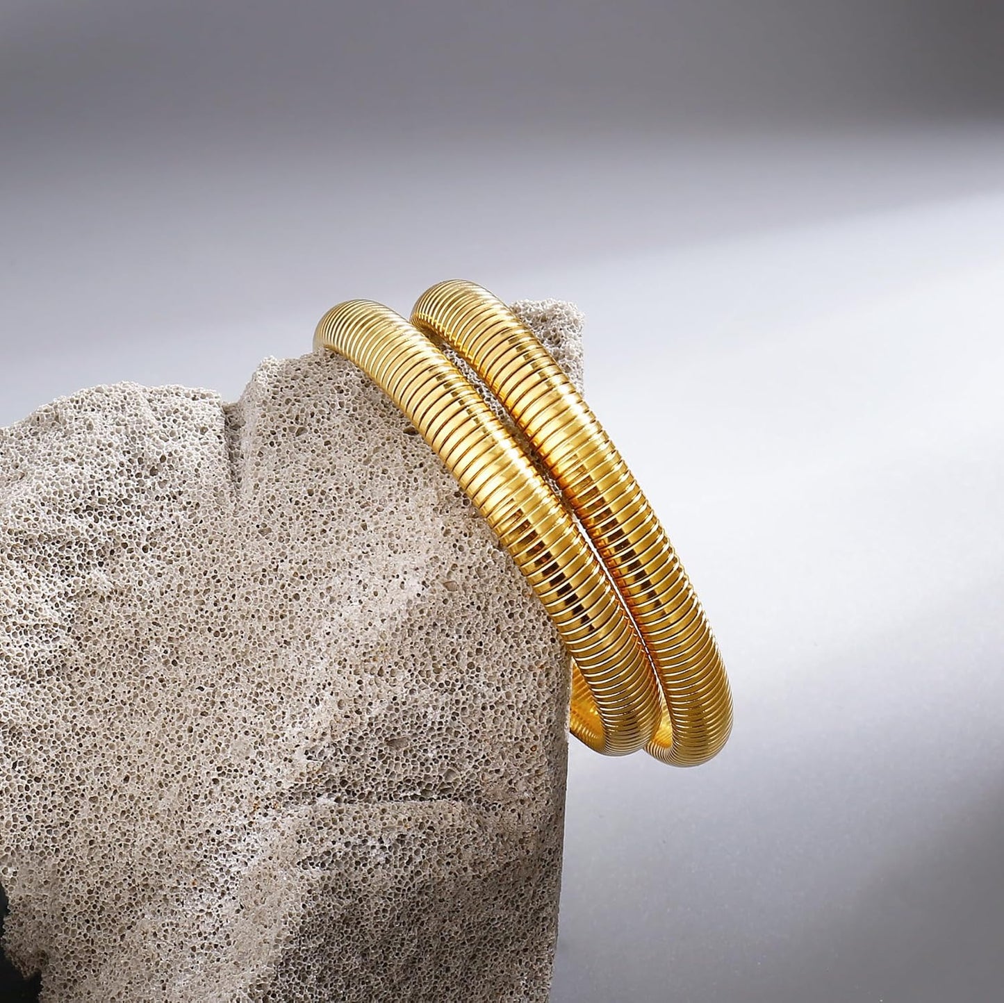 Wide gold bangle bracelet showing stretchy design