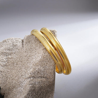 Wide gold bangle bracelet showing stretchy design