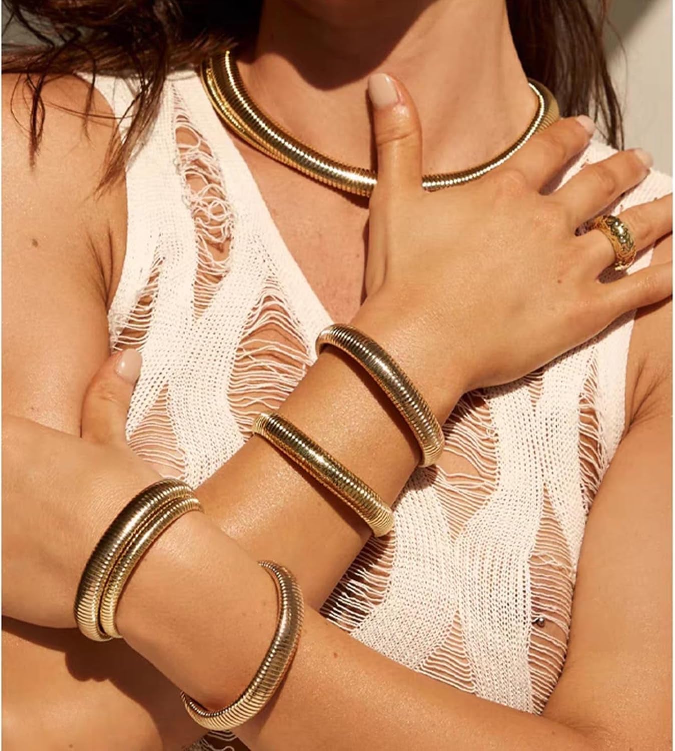 Three chunky gold bangles arranged in stack formation