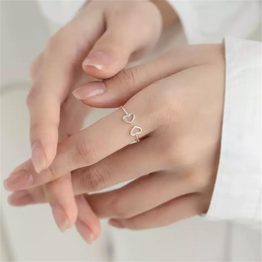 Double heart statement ring worn on female finger showing fit