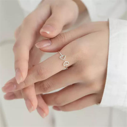 Double heart statement ring worn on female finger showing fit