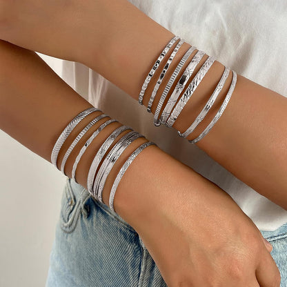 Woman wearing multiple layered gold stackable bracelets on wrist