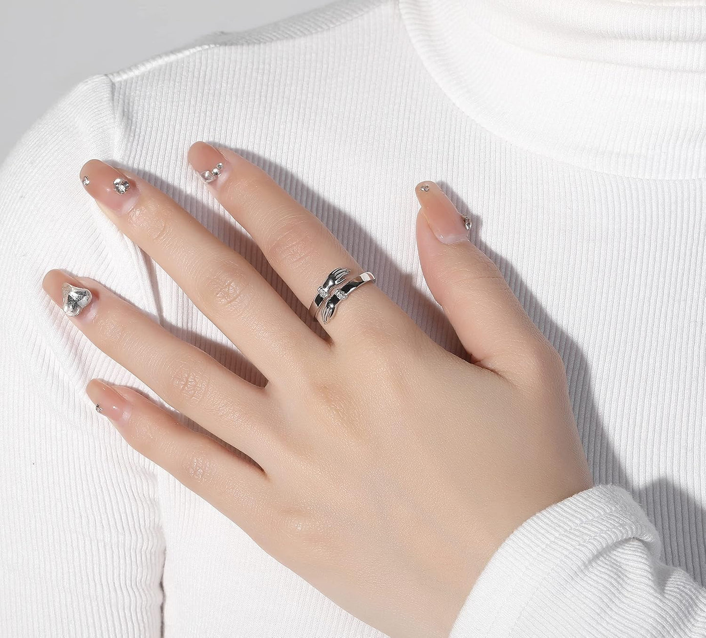 Woman wearing silver hug ring showing hand design detail