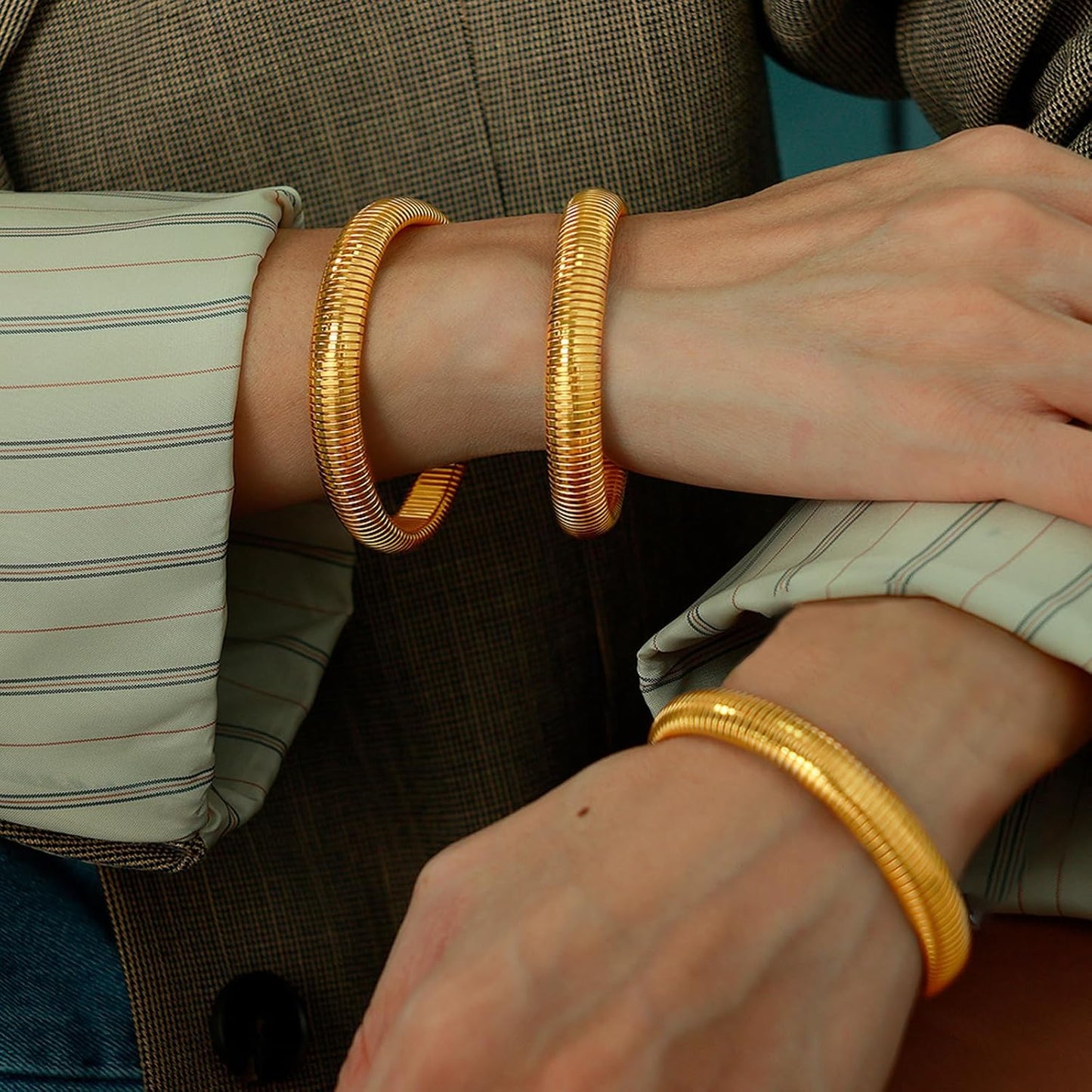 Gold chunky bangles worn as stacked bracelet set