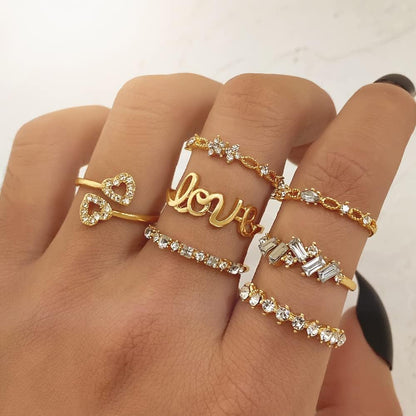 Gold stacking rings set on woman's hand showing full collection