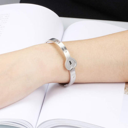 Woman and man wearing matching heart key lock bangles