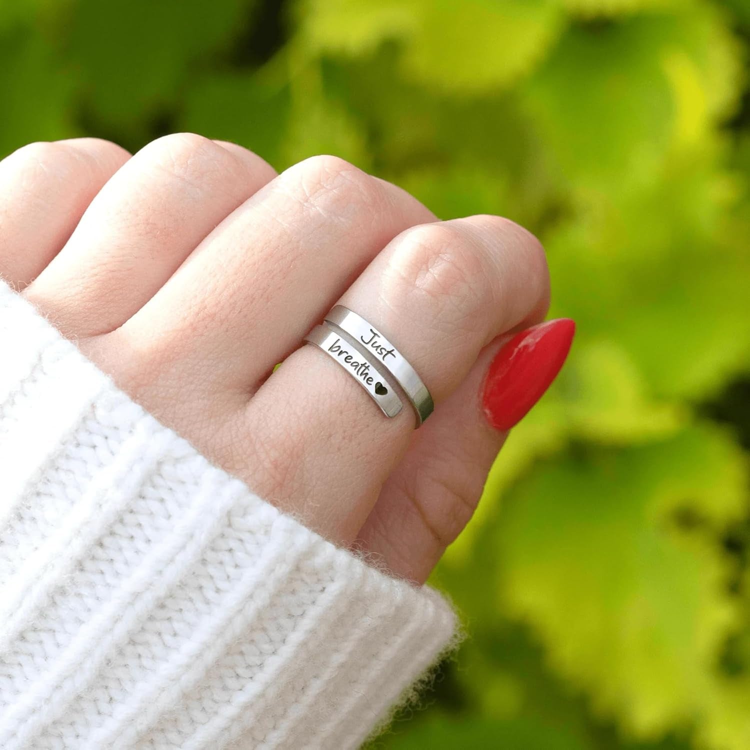 Close-up of polished stainless steel heart ring showing spiral wrap detailing