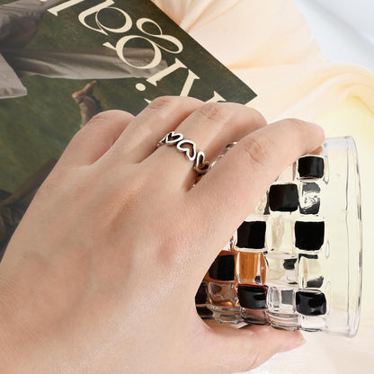 Minimalist open heart ring worn as statement thumb ring