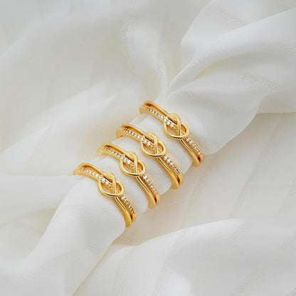 Multiple gold stackable rings arranged together on white background