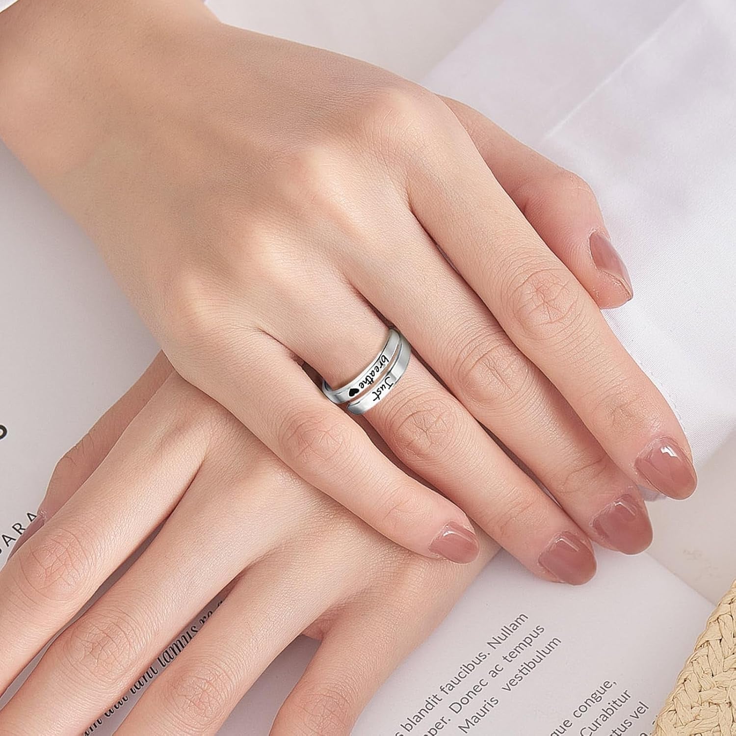 Silver promise ring displayed on woman's hand showing adjustable fit