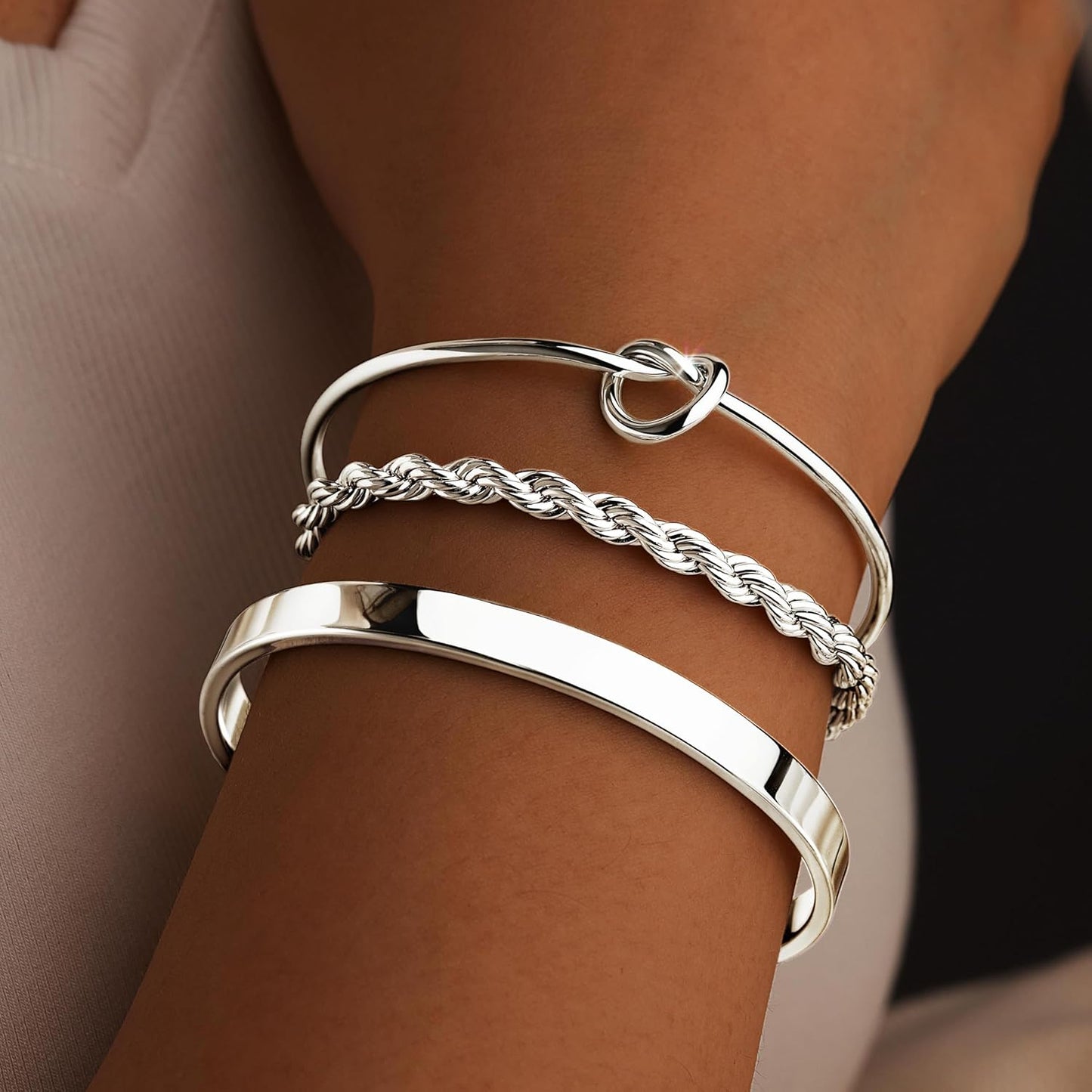 Multiple silver cuff bangles layered together for trendy look