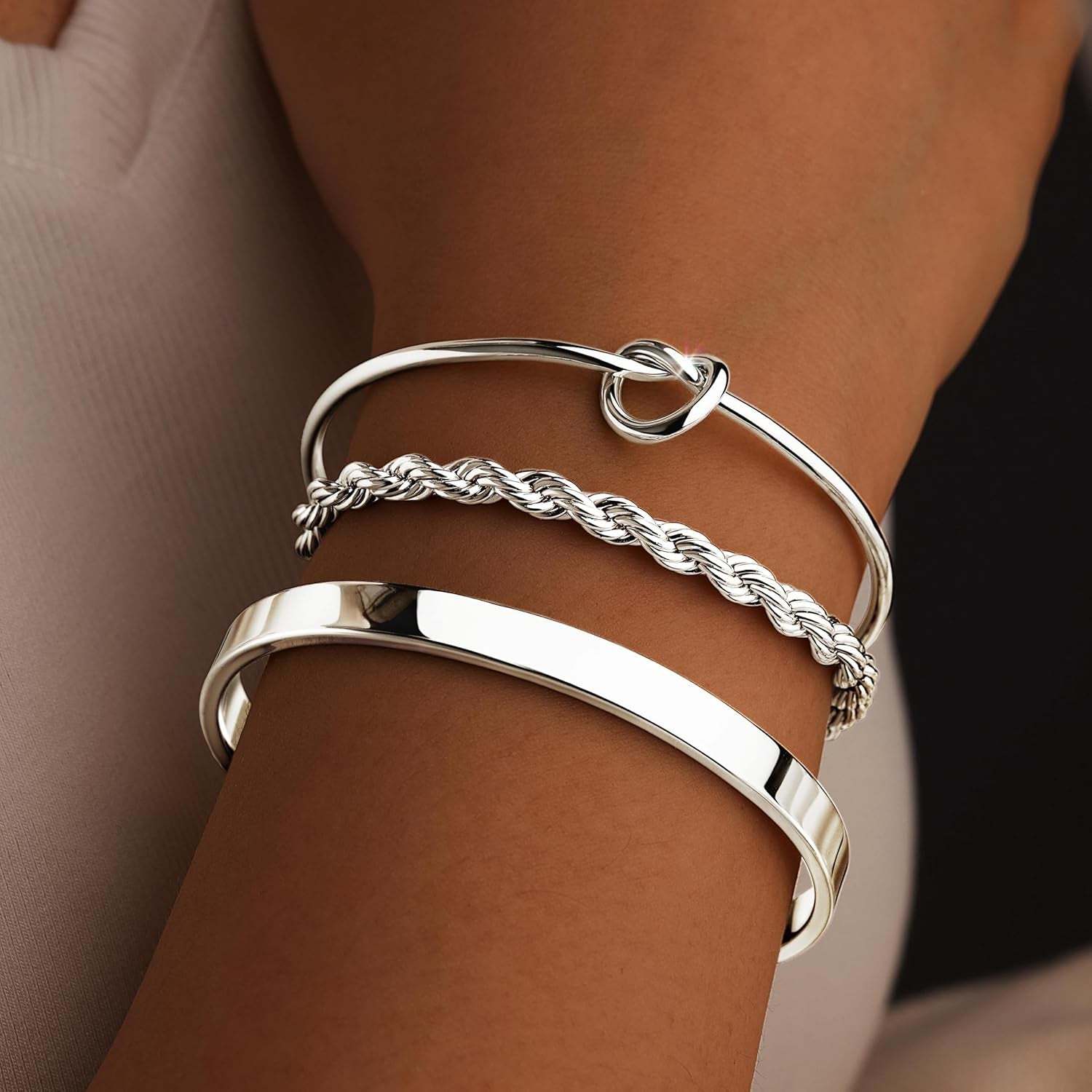 Multiple silver cuff bangles layered together for trendy look