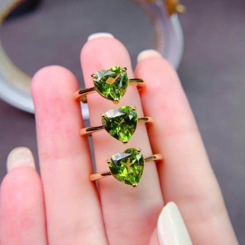Peridot love ring worn on woman's hand showing color and sparkle