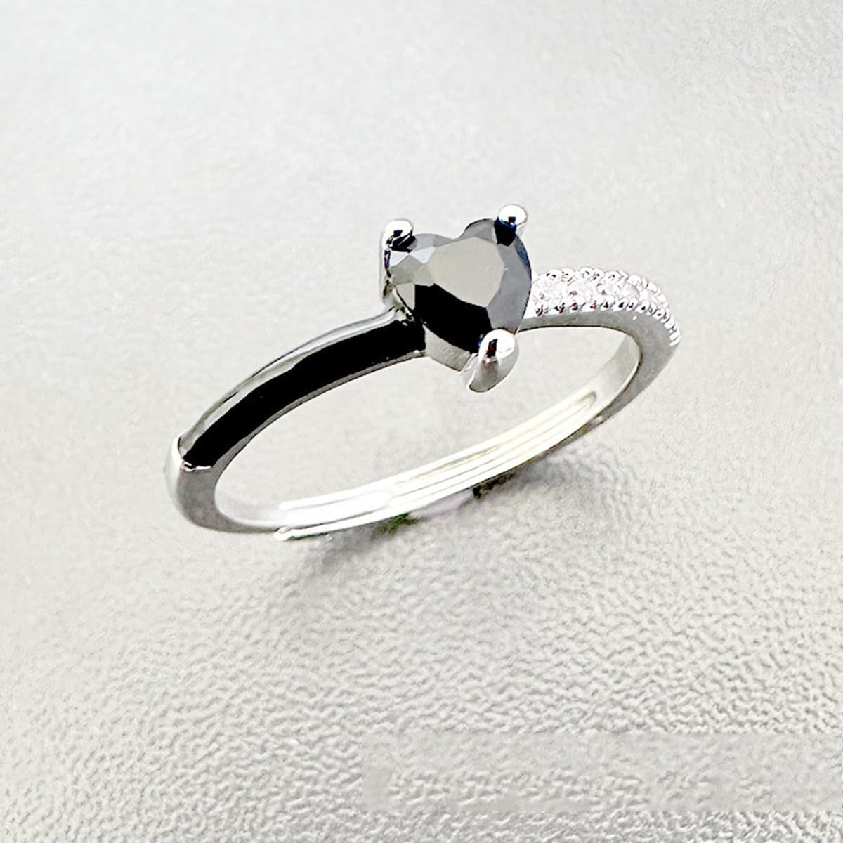 Black heart reminder ring worn on woman's hand