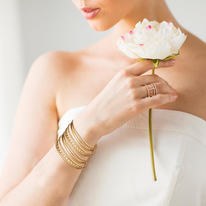 Gold bangle bracelet set styled on wrist showing stackable fit