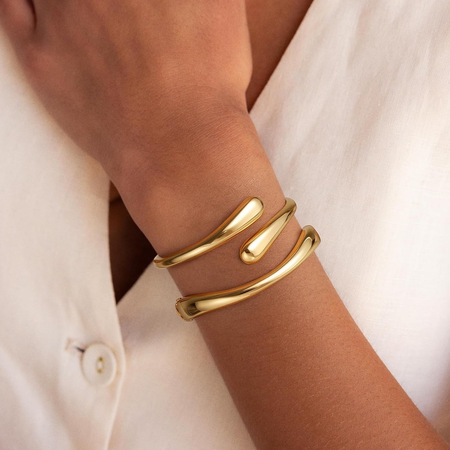 Gold plated twisted cuff bangle bracelets stacked on wrist